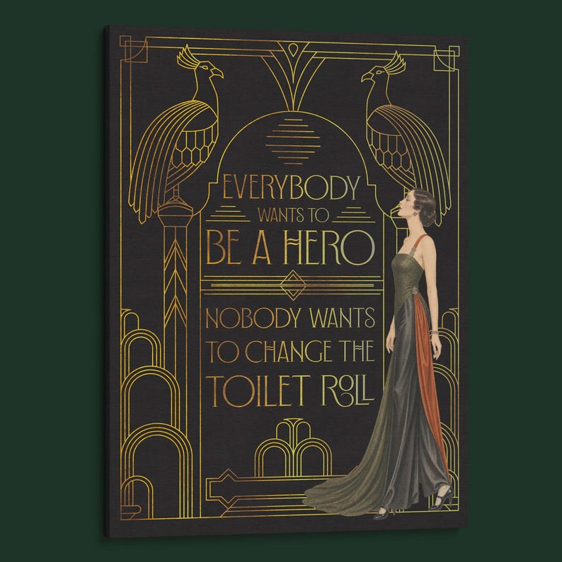 Pu&ograve; includere: Una stampa murale rettangolare nera con disegni a linee dorate di due pavoni e motivi geometrici. Il testo recita: EVERYBODY WANTS TO BE A HERO, NOBODY WANTS TO CHANGE THE TOILET ROLL. Una figura in un lungo abito scuro si trova a destra.