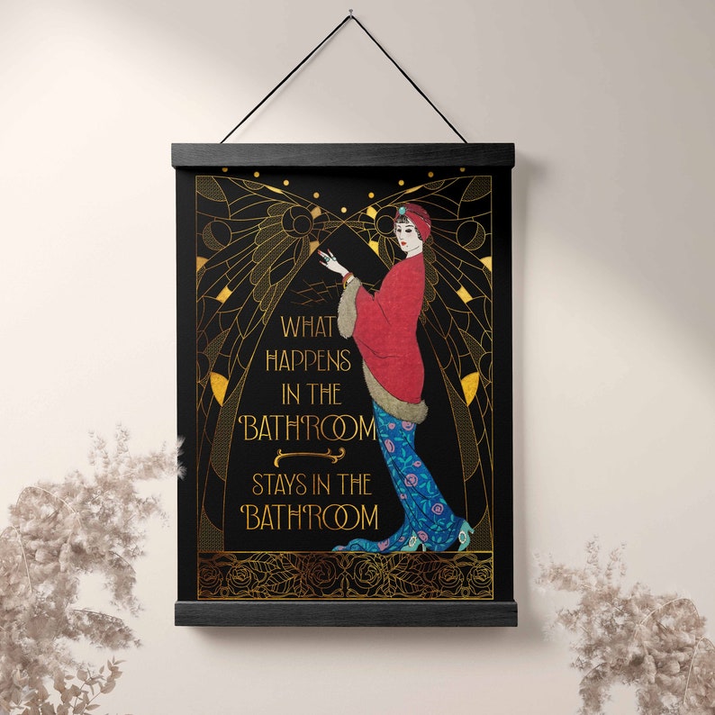 May include: A black and gold art print with a woman in a red and blue dress. The print has the text "What happens in the bathroom stays in the bathroom".