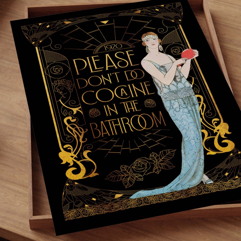 May include: Art Deco style print with a black background and gold accents. The print features a woman in a blue dress and the text "PLEASE DON'T DO COCAINE IN THE BATHROOM" in gold lettering. The print is set in a wooden tray.