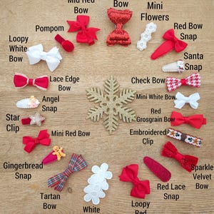 May include: Assortment of Christmas-themed hair bows and clips.  Includes red, white, and tartan bows, glitter bows, mini white bows, a red grosgrain bow, a star clip, a gingerbread snap, a lace edge bow, an angel snap, a red bow snap, a Santa snap, a sparkle velvet bow, a loopy red bow, and white flowers.