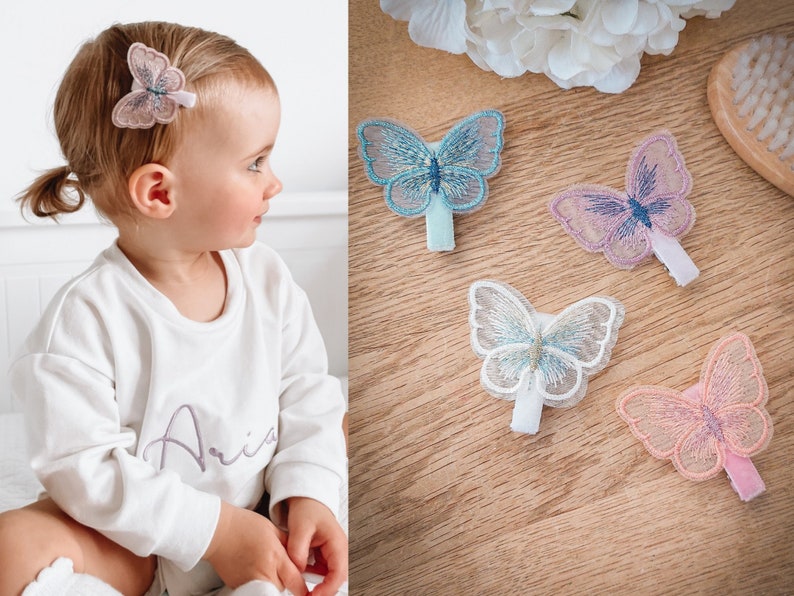 K&ouml;nnte beinhalten: Vier Schmetterlingshaarspangen in verschiedenen Farben. Die Spangen bestehen aus einem zarten, durchsichtigen Stoff mit Stickereien. Die Schmetterlinge sind in Blaut&ouml;nen, Rosa und Lila.