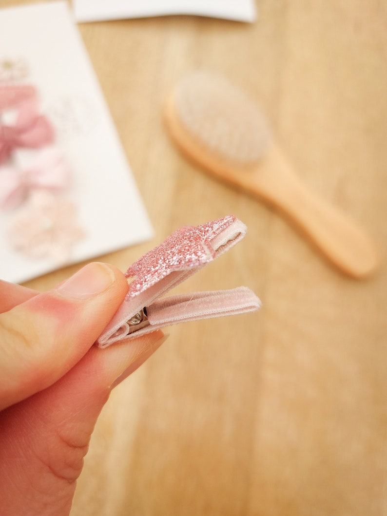 以下が含まれることがあります： ピンクのグリッタースターのヘアクリップで、ピンクのベルベットのバンドが付いています。