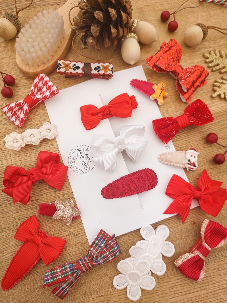 May include: A set of 12 Christmas-themed hair clips featuring red, white, and gold bows, stars, and lace. The clips are perfect for adding a festive touch to any outfit.