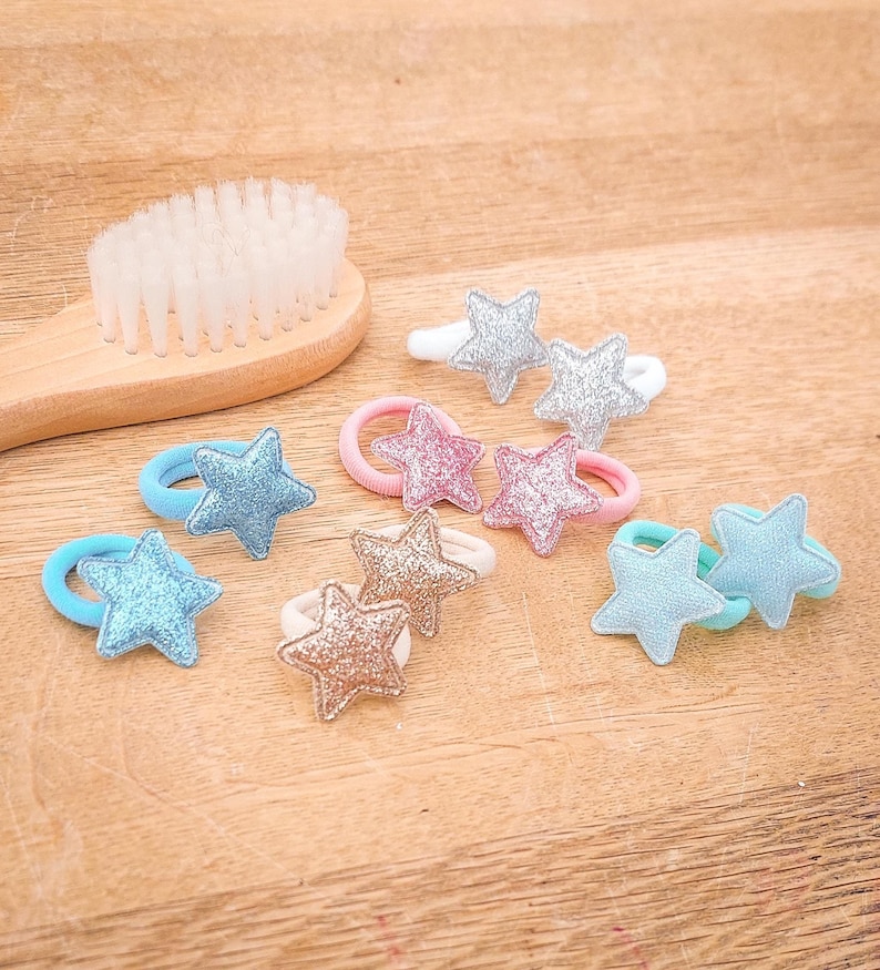 Pu&ograve; includere: Un set di otto scrunchies per capelli con decorazioni in tessuto a forma di stella in vari colori, tra cui rosa, blu, argento e oro. Gli scrunchies sono realizzati in elastico e sono adatti per tenere i capelli in posizione.