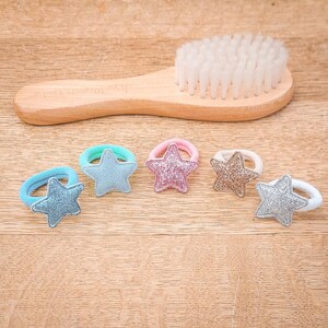 Pu&ograve; includere: Sei elastici per capelli colorati con ciondoli a forma di stella. Gli elastici per capelli sono elastici e hanno una finitura scintillante.