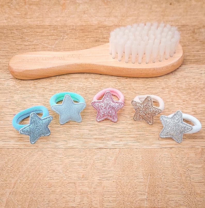 Pu&ograve; includere: Sei elastici per capelli colorati con ciondoli a forma di stella. Gli elastici per capelli sono elastici e hanno una finitura scintillante.