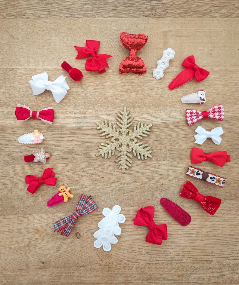 May include: A collection of 18 red and white hair bows with various designs, including plaid, glitter, and snowflakes. The bows are arranged in a circle around a gold snowflake on a wooden surface.
