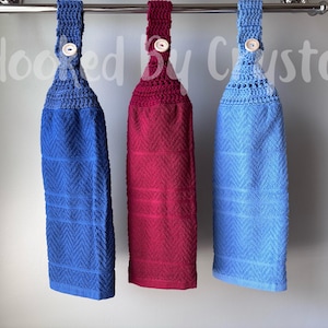Pode incluir: Tr&ecirc;s toalhas de cozinha penduradas em azul royal, magenta escuro e azul claro, cada uma com um topo de croch&ecirc; com fecho de bot&atilde;o de madeira. As toalhas t&ecirc;m um padr&atilde;o de chevron texturizado e est&atilde;o suspensas numa barra de metal prateado.