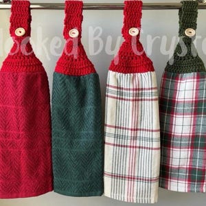 Pode incluir: Quatro panos de prato pendurados com topos de croch&ecirc; em vermelho e verde escuro, cada um preso com um bot&atilde;o claro. As toalhas apresentam um vermelho s&oacute;lido, um verde escuro s&oacute;lido e dois padr&otilde;es xadrez em vermelho, verde e branco.