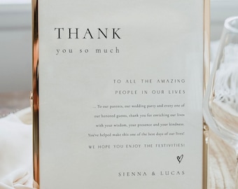 May include: A gold-framed sign with a white background and black text that reads "THANK you so much TO ALL THE AMAZING PEOPLE IN OUR LIVES... To our parents, our wedding party and every one of our honored guests, thank you for enriching our lives with your wisdom, your presence and your kindness. You've helped make this one of the best days of our lives! WE HOPE YOU ENJOY THE FESTIVITIES! ♡ SIENNA & LUCAS"
