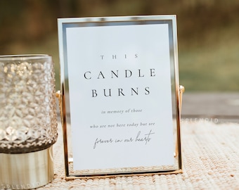May include: A gold-framed sign with the text "THIS CANDLE BURNS in memory of those who are not here today but are forever in our hearts".