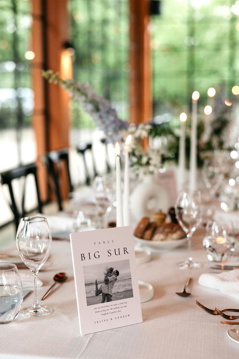May include: A white table number card with the text "TABLE BIG SUR" and a black and white photo of a couple on a beach. The text below the photo reads "On our third date we took a road trip down to Big Sur. We walked, we laughed, it was a perfect day.  CELINE & ANDREW"