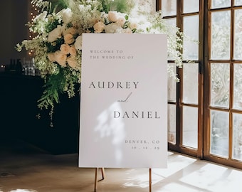 May include: White wedding welcome sign with black text that reads "Welcome to the wedding of Audrey and Daniel, Denver, CO 10.12.29".