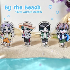 May include: Four clear acrylic standees featuring anime-style characters at the beach. Each character is dressed in summer attire and holding beach-themed items. The text "By the Beach" and "Thick Acrylic Standee" is visible in the background.