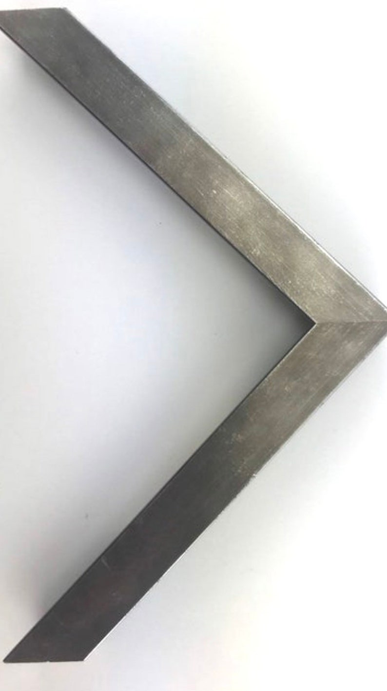 May include: A silver metal picture frame with a beveled edge. The frame is made of a thin metal and has a slightly distressed finish.