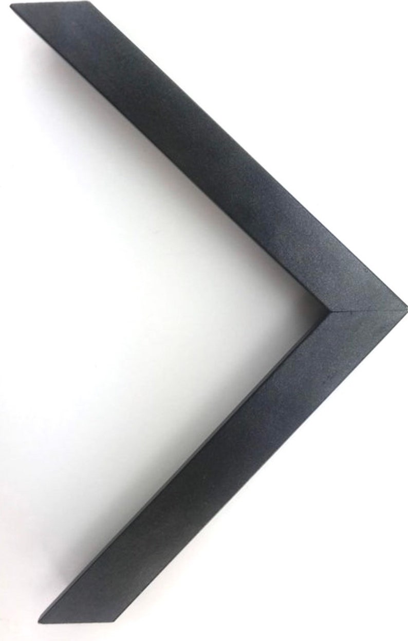 May include: A black picture frame corner with a smooth, matte finish.