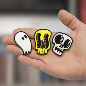 May include: A set of three ceramic mugs with a speckled, matte finish. The mugs are in shades of cream, light gray, and dark gray. Each mug has a simple, minimalist design, perfect for coffee or tea.