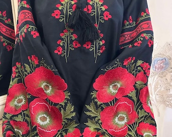 May include: Black embroidered blouse with red poppy flowers and green leaves. The blouse has a gathered neckline and long sleeves.