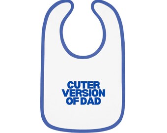 May include: White baby bib with a blue trim and the text "Cuter Version of Dad" in blue. The bib is designed to catch spills and protect clothing during feeding time.