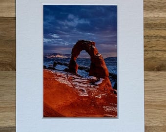 Photo of Arches National Park's Delicate Arch with a Dusting of Snow at Sunset