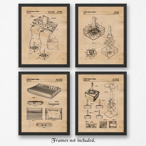 Puede incluir: Conjunto de cuatro impresiones de estilo vintage con ilustraciones en blanco y negro de mandos y consolas de videojuegos. Las impresiones están enmarcadas en marcos negros y tienen un fondo beige.