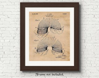 May include: A vintage patent drawing for a spring-loaded toy, showing two hands holding the toy in different positions. The patent number is 2,418,812 and the date is June 28, 1947.