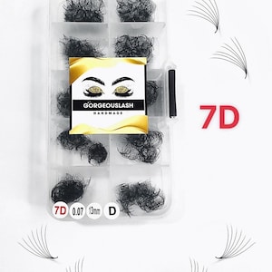 Könnte beinhalten: Ein transparenter Plastikbehälter mit 8 Fächern, gefüllt mit schwarzen Wimpernextensions. Der Behälter trägt ein Etikett mit der Aufschrift "GorgeousLash Handmade". Der Text "7D 0.07 13mm D" ist auf dem Boden des Behälters aufgedruckt. Es befinden sich 3 einzelne Wimpernextensions auf weißem Hintergrund.