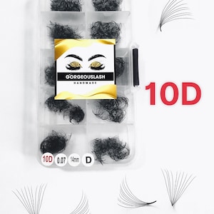 May include: A clear plastic case containing clusters of black eyelash extensions. The case has a label that reads "GORGEOUSLASH HANDMADE" with an illustration of gold glitter eyelashes. The text "10D 0.07 14mm D" is also visible.
