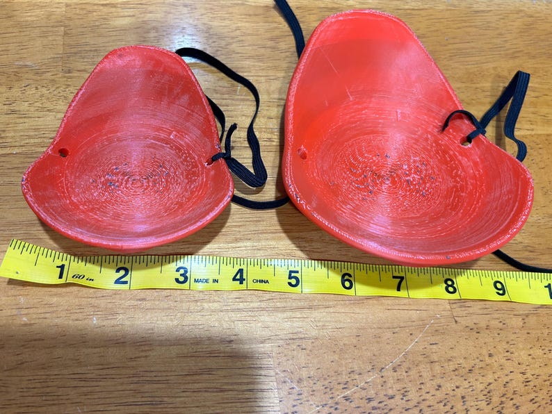 May include: Two red plastic eye masks with black elastic straps. The masks are about 3 inches wide and 4 inches long.