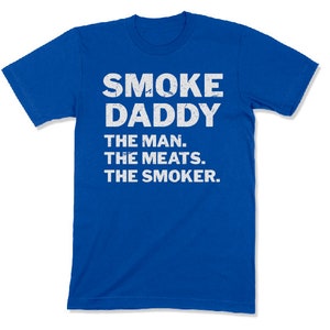 Pu&ograve; includere: Una t-shirt a maniche corte color blu reale con testo bianco in stile consumato che recita: SMOKE DADDY, THE MAN. THE MEATS. THE SMOKER. La maglietta presenta un girocollo e una vestibilit&agrave; standard, con la grafica centrata sul petto.