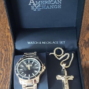 Conjunto de reloj de pulsera y collar con cruz para hombre de American Exchange, con esfera negra y cronógrafo. Nuevo en caja. Artículo de colección.