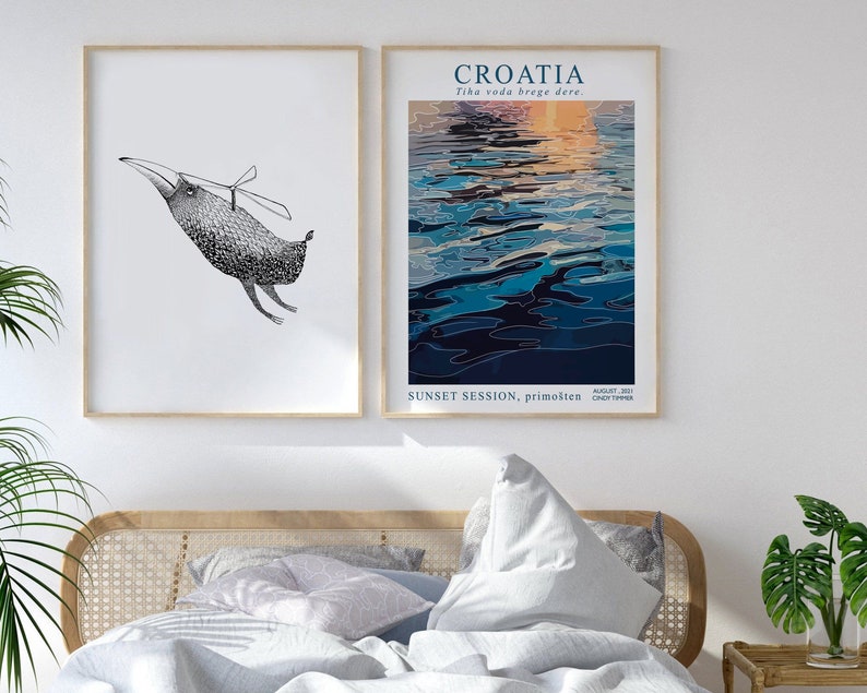 May include: Two framed prints, one with a black and white illustration of a bird with a propeller on its back, and the other with a blue and orange abstract painting of water with the text "CROATIA Tihа voda brege dere. AUGUST 2021 SUNSET SESSION, primo&scaron;ten CROATIA TIMER"
