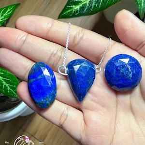 以下が含まれることがあります： 銀のチェーンに3つのラピスラズリ宝石のペンダント。ペンダントは、涙型、楕円形、丸形の3種類。宝石は濃い青色です。
