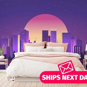 May include: A bedroom featuring a wall mural of a purple city skyline at night with a large pink sun. The bed has white bedding and peach pillows. Two wooden nightstands with lamps and a plant are on either side of the bed on a light wood floor.