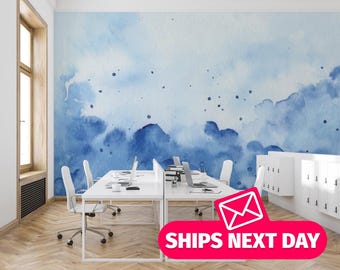 Puede incluir: Un espacio de oficina con escritorios, sillas y computadoras portátiles blancas. La pared presenta un mural de acuarela azul. La imagen incluye el texto "SHIPS NEXT DAY" en una pancarta rosa con un icono de sobre.