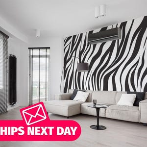 May include: A white and black zebra print wallpaper mural in a modern living room with a white sectional sofa, a black coffee table, and black blinds on the windows.
