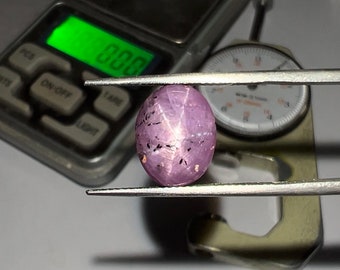 May include: A pink star sapphire gemstone with black inclusions, measuring approximately 10mm in diameter.