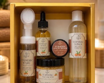 May include: A skincare gift set in a gold box containing a Turmeric Wash with a brush applicator, a Turmeric Serum, a Turmeric Face Cream, a Turmeric Face Scrub, and a Turmeric Toner. Each bottle and jar features a label with the brand name Smooth Like Joi.