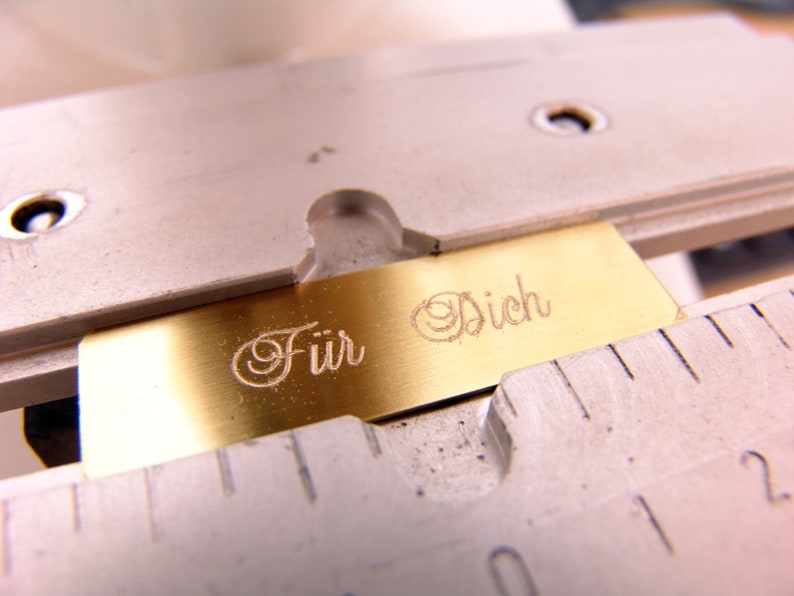May include: A gold-colored metal plate with the words "F&uuml;r Dich" engraved in a cursive font.