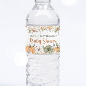 May include: A clear plastic water bottle with a white label that says "Marie Davidson's Baby Shower" with a floral design and pumpkins.