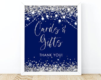 May include: A navy blue sign with silver glitter and white string lights that reads "Cards & Gifts" and "Thank You!"