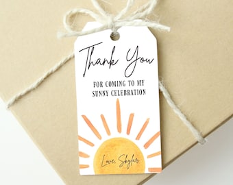 May include: White thank you tag with a watercolor sun design in shades of orange and yellow. The text reads "Thank You for coming to my sunny celebration Love, Skylar".