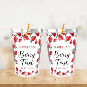 May include: Two white juice pouches with a straw sticking out of the top. The pouches have a red and green strawberry pattern and the text "Isabella's Berry First Birthday".