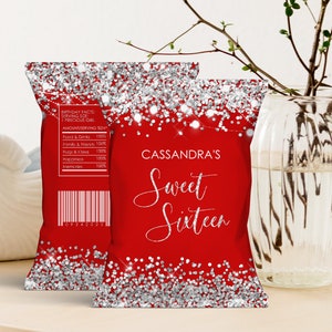 May include: Red and silver glitter party favor bags with the text "Cassandra's Sweet Sixteen" printed on the front. The bags are decorated with silver glitter and a string of lights.