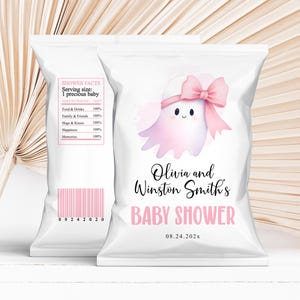 May include: White baby shower favor bags with pink accents. One bag features a pink ghost illustration with a bow and the text "Olivia and Winston Smith's BABY SHOWER". The other bag has a "SHOWER FACTS" label and a pink barcode.
