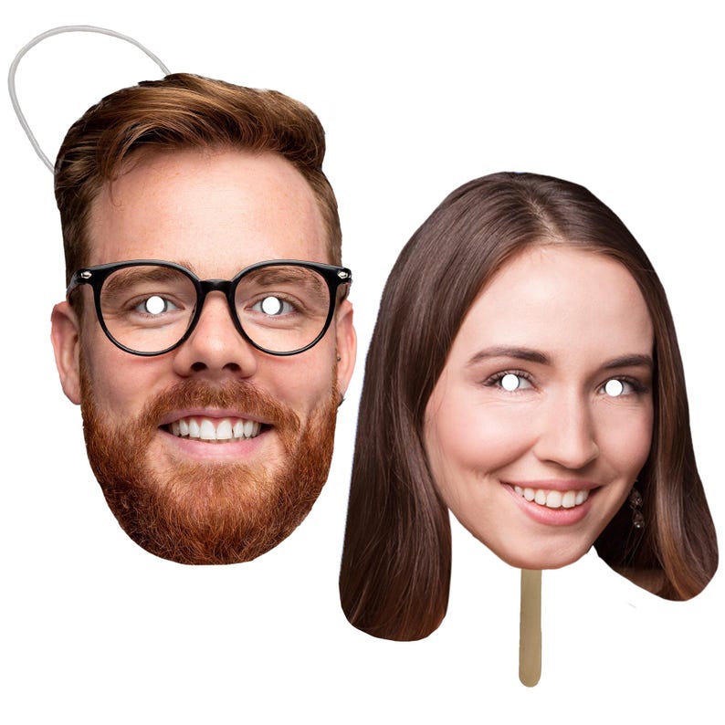 May include: Two cardboard face masks, one with a man's face wearing glasses and a beard, and the other with a woman's face. Both masks have white circles for eyes.
