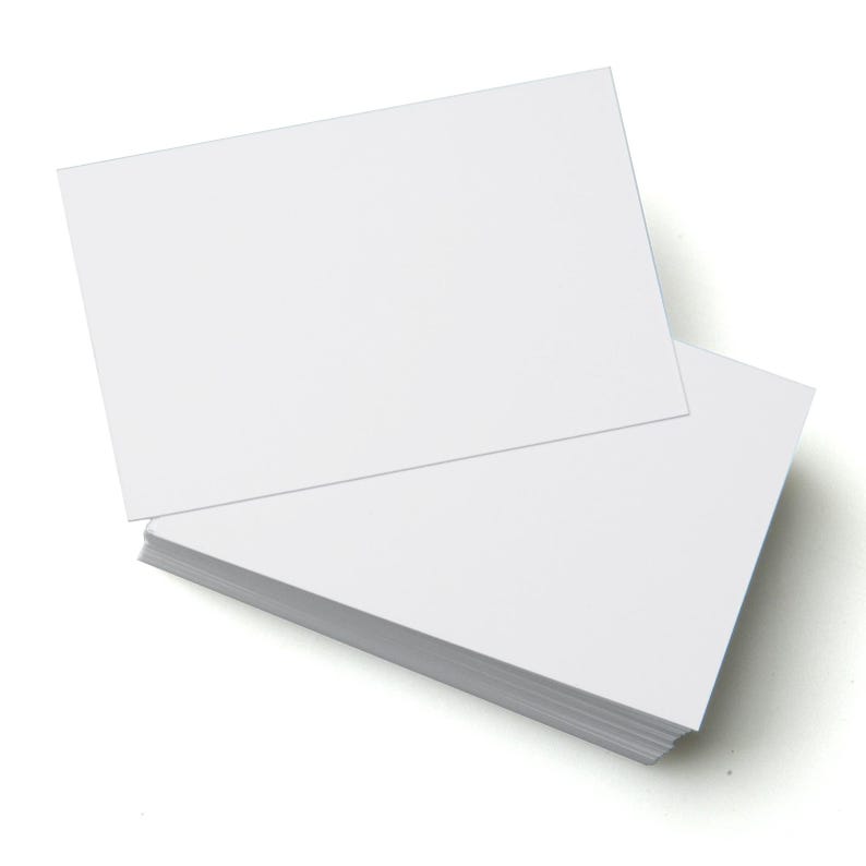 A stack of blank white business cards with one card placed on top at an angle, highlighting its smooth, clean surface against a white background.