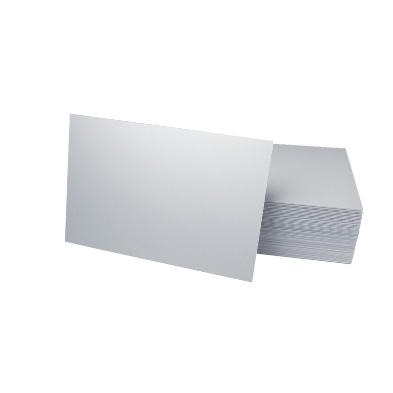 A stack of blank white business cards with one card positioned upright in front, showcasing the card's plain surface against a white background.