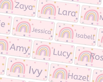 Może przedstawiać: Różowe i białe etykiety z imionami z motywem tęczy i złotymi gwiazdkami. Etykiety zawierają imiona Zaya, Becky, Jodie, Lara, Jessica, Isabelt, Amy, Lucy, Ros, Ivy, Hazet i Ruby.