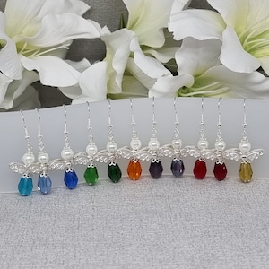 May include: A set of eight silver angel wing earrings with a pearl bead and a crystal drop. The crystals are in a rainbow of colours: blue, teal, green, orange, purple, red, and yellow.